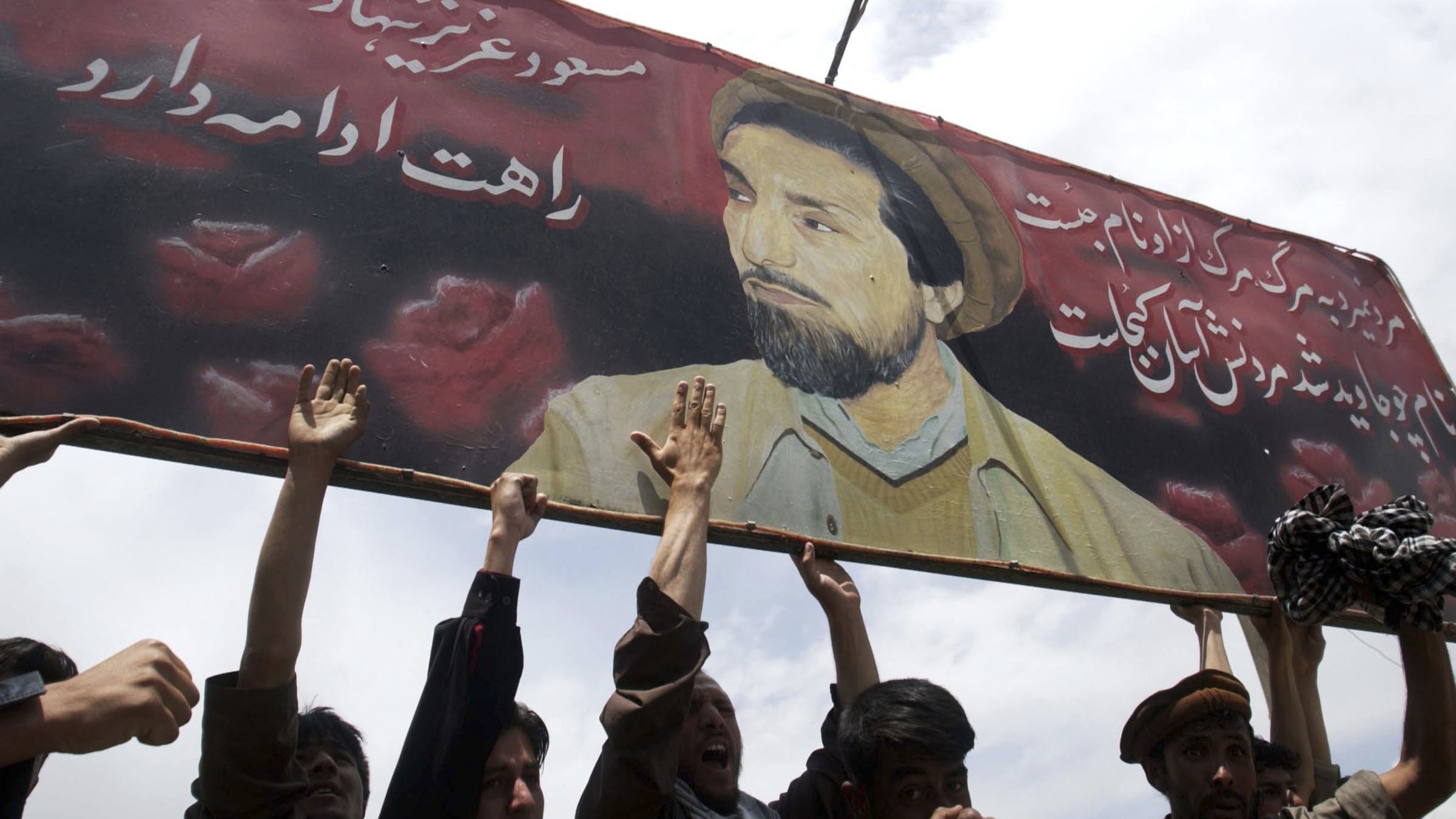 Afghans protest under an image of the late Ahmad Shah Massoud in Kabul in 2003