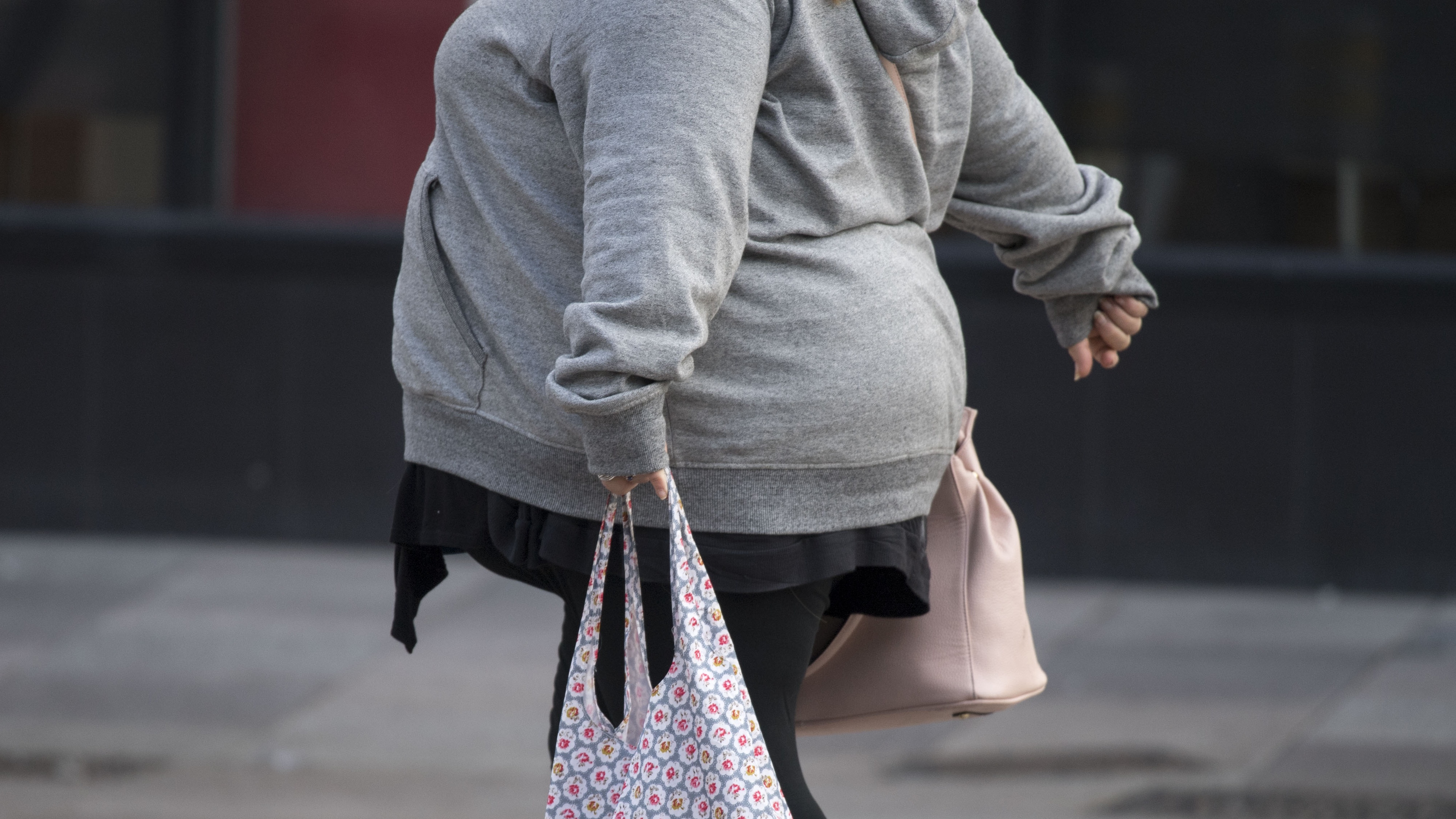 Obese woman walking on pavement