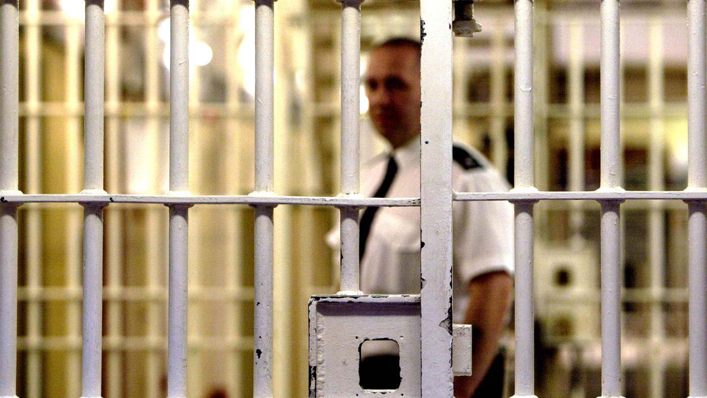 A prison guard behind bars