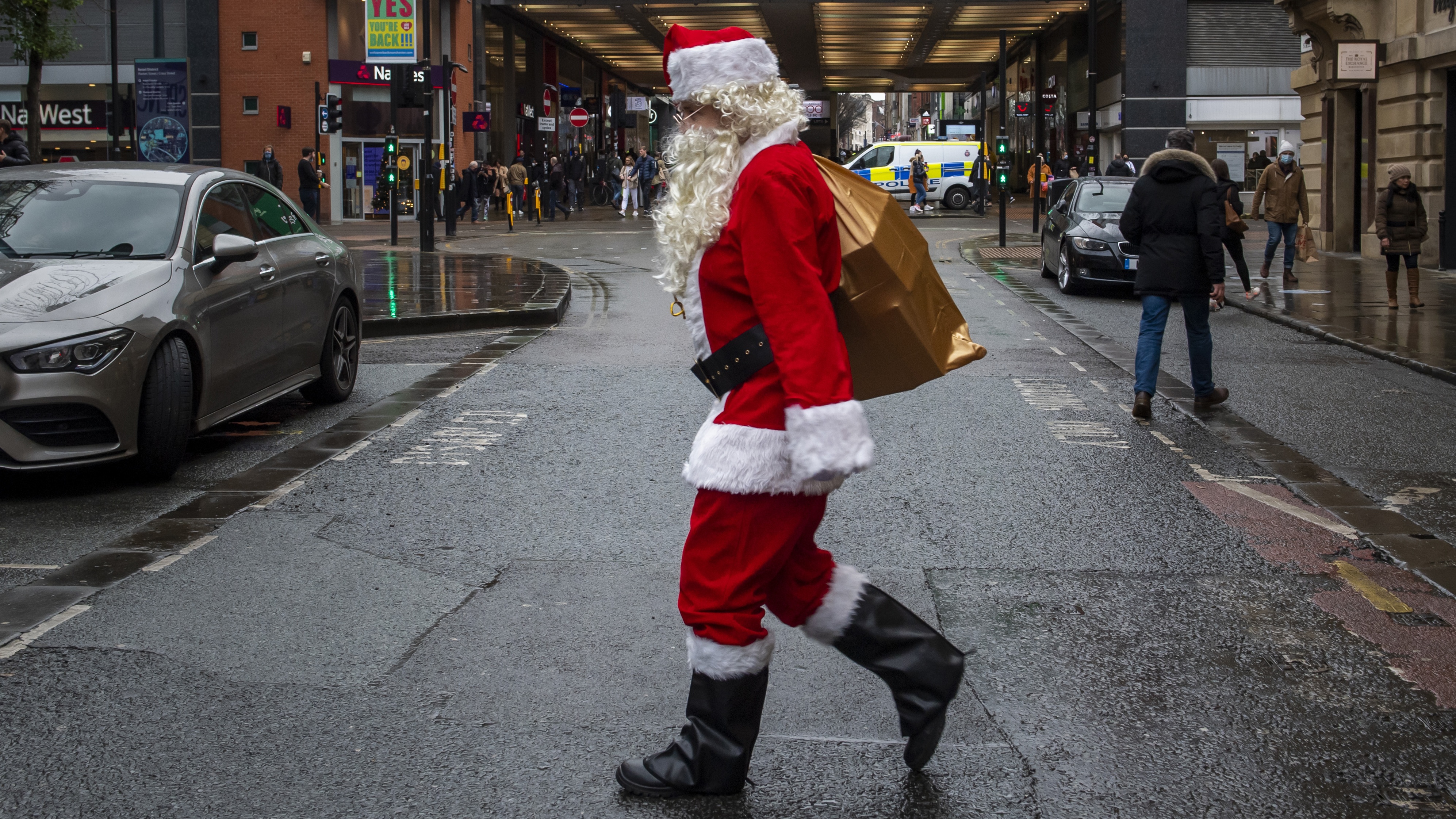A man dressed as Santa Claus walks through Manchester city center