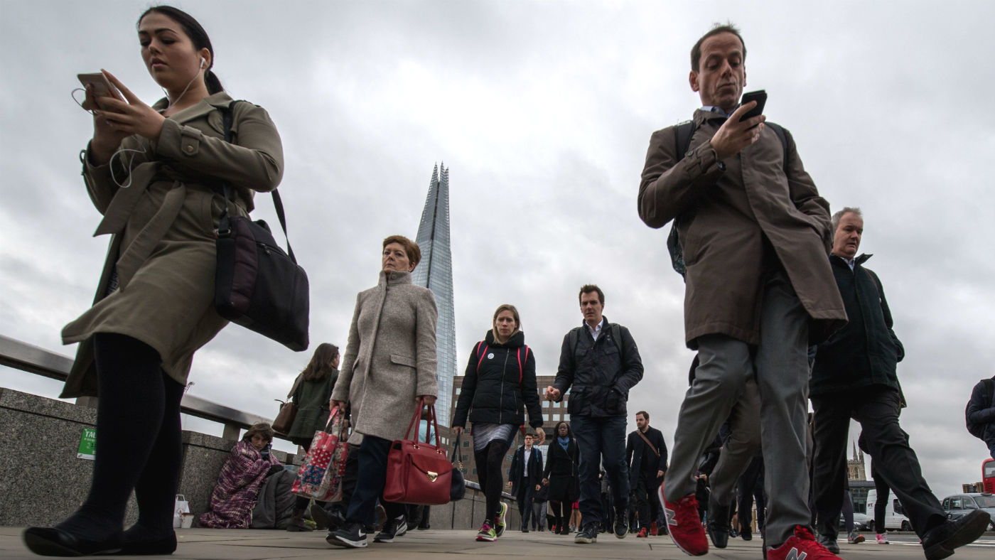 Commuters check their phone crossing London Bridge