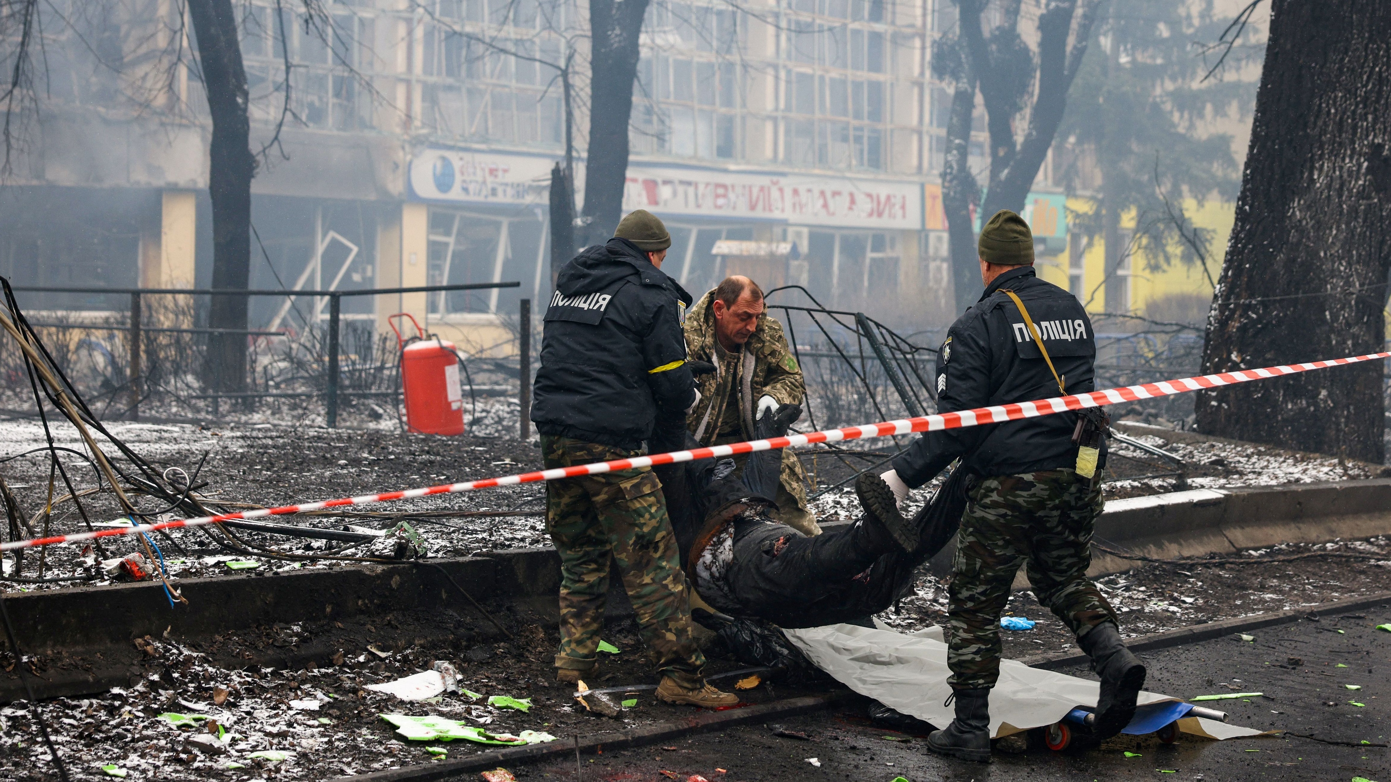 2 March: Emergency service workers remove the body of a man killed after Russia shelled Kyiv’s main television tower