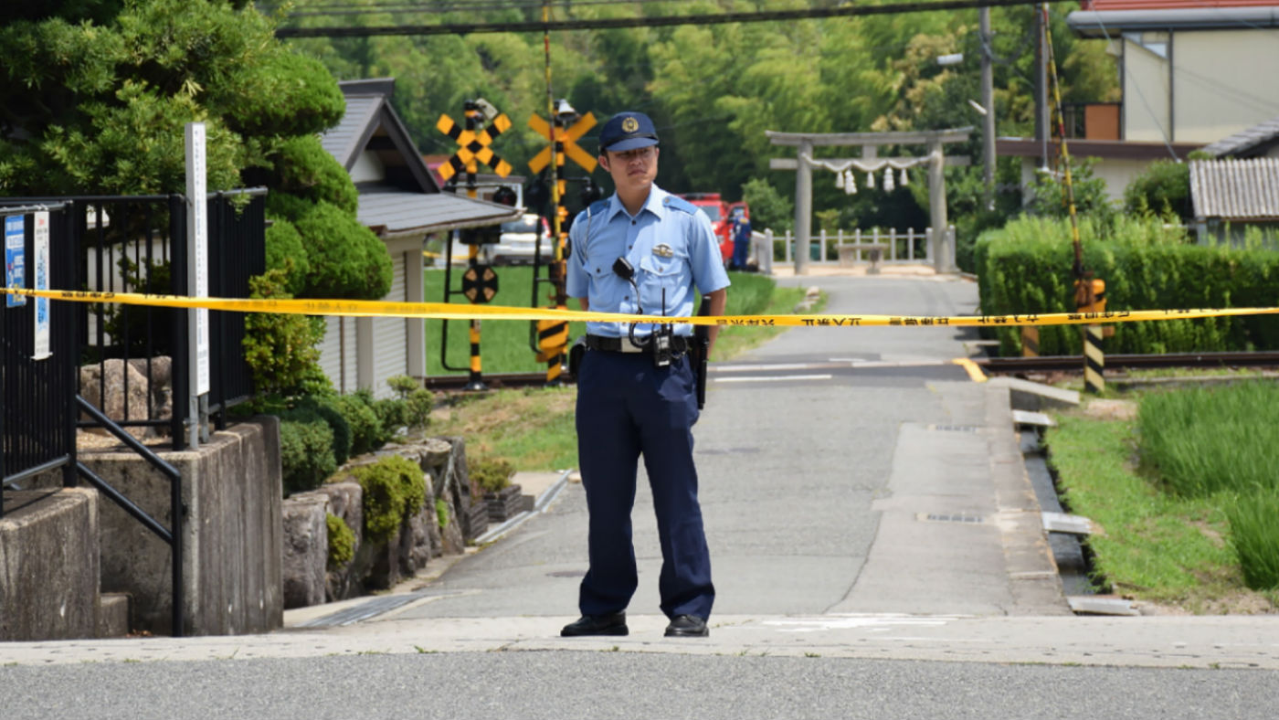 A Japanese policeman stands guard at a crime scene