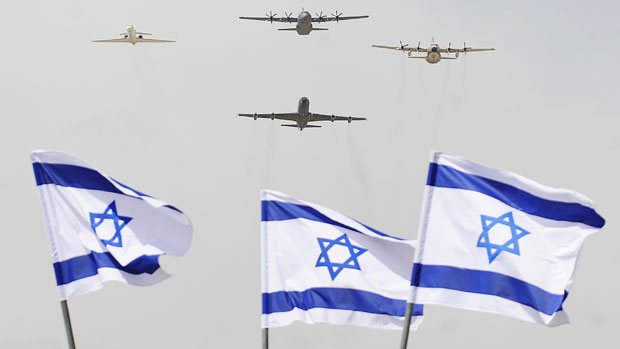Israeli military planes fly over flags