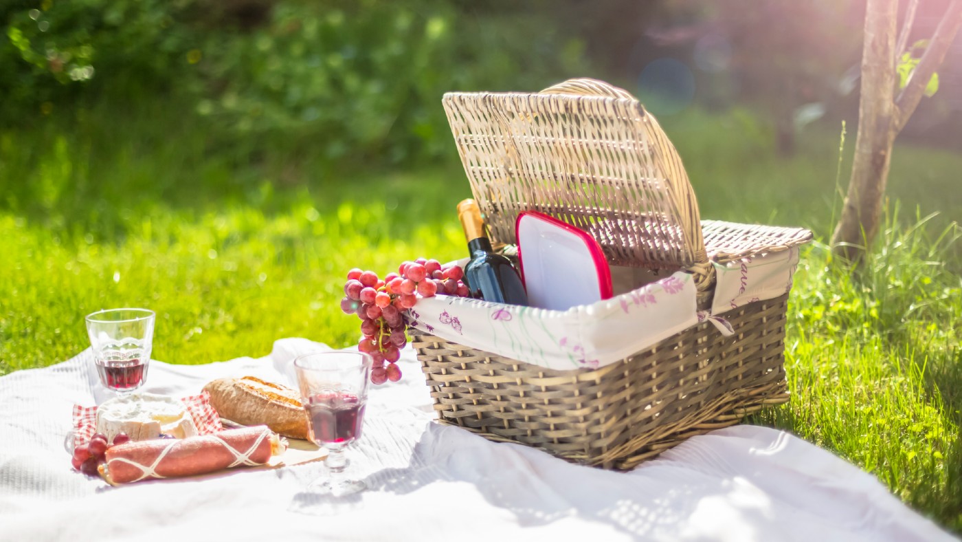 Picnic hamper with food on a picnic blanket