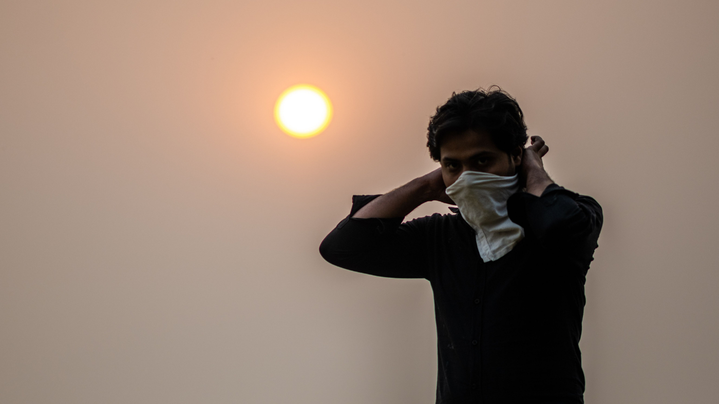 Man covers face from smog