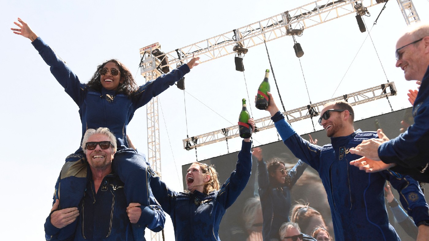 Richard Branson cheers with crew members after flying into space 
