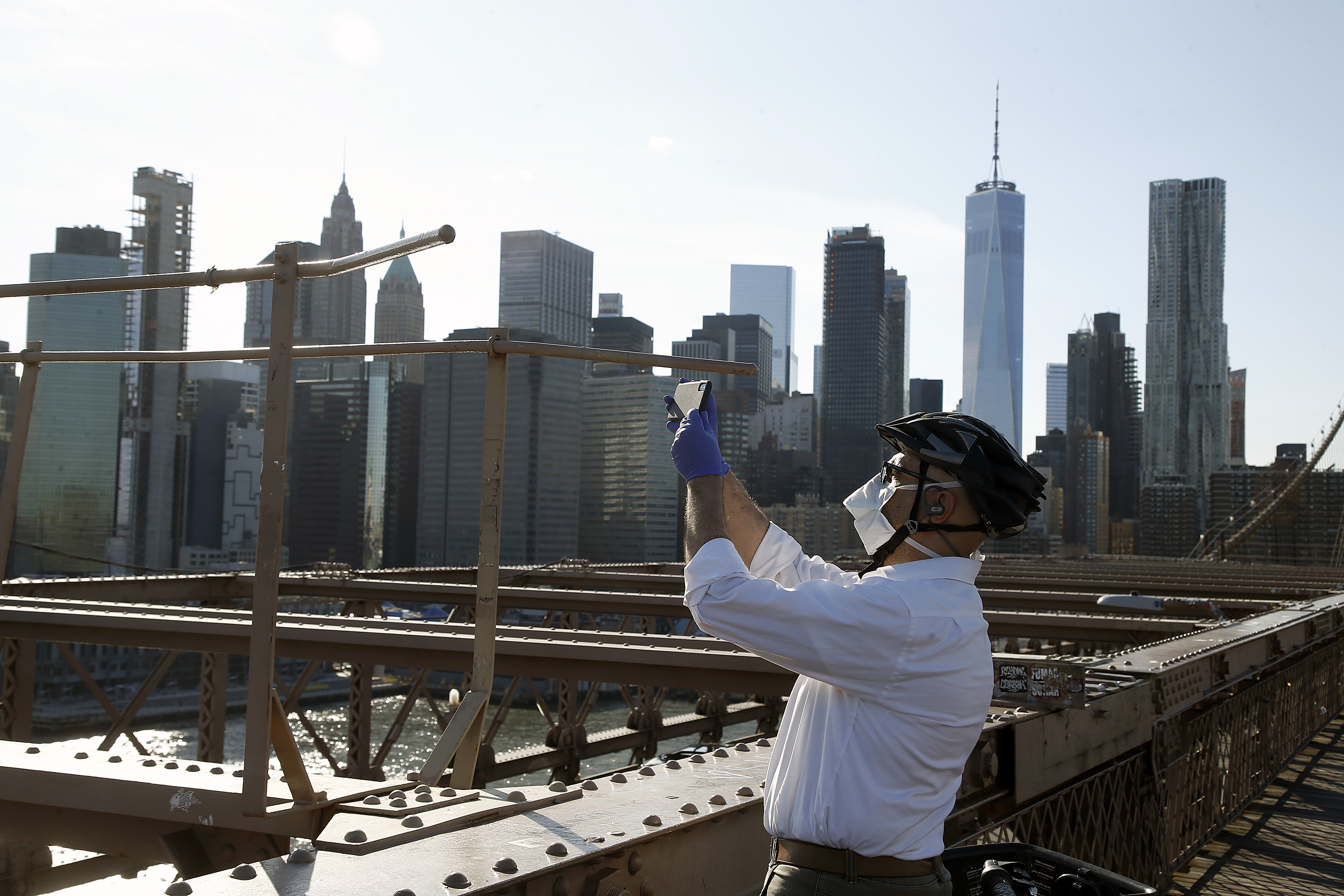 NEW YORK, NEW YORK - APRIL 28:A man takes a photograph on the Brooklyn Bridge during the coronavirus pandemic on April 28, 2020 in New York City. COVID-19 has spread to most countries around 