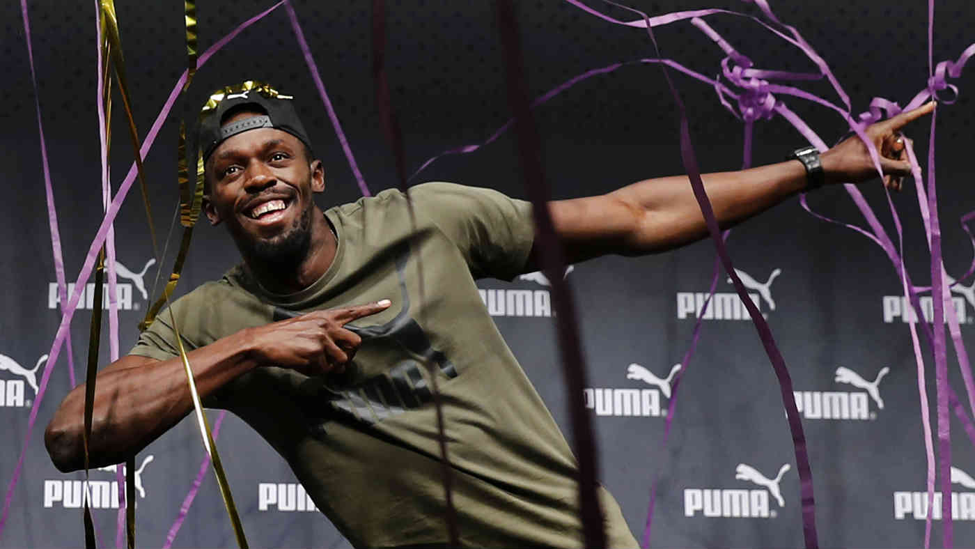 Usain Bolt strikes a familiar pose at a press conference ahead of his final race