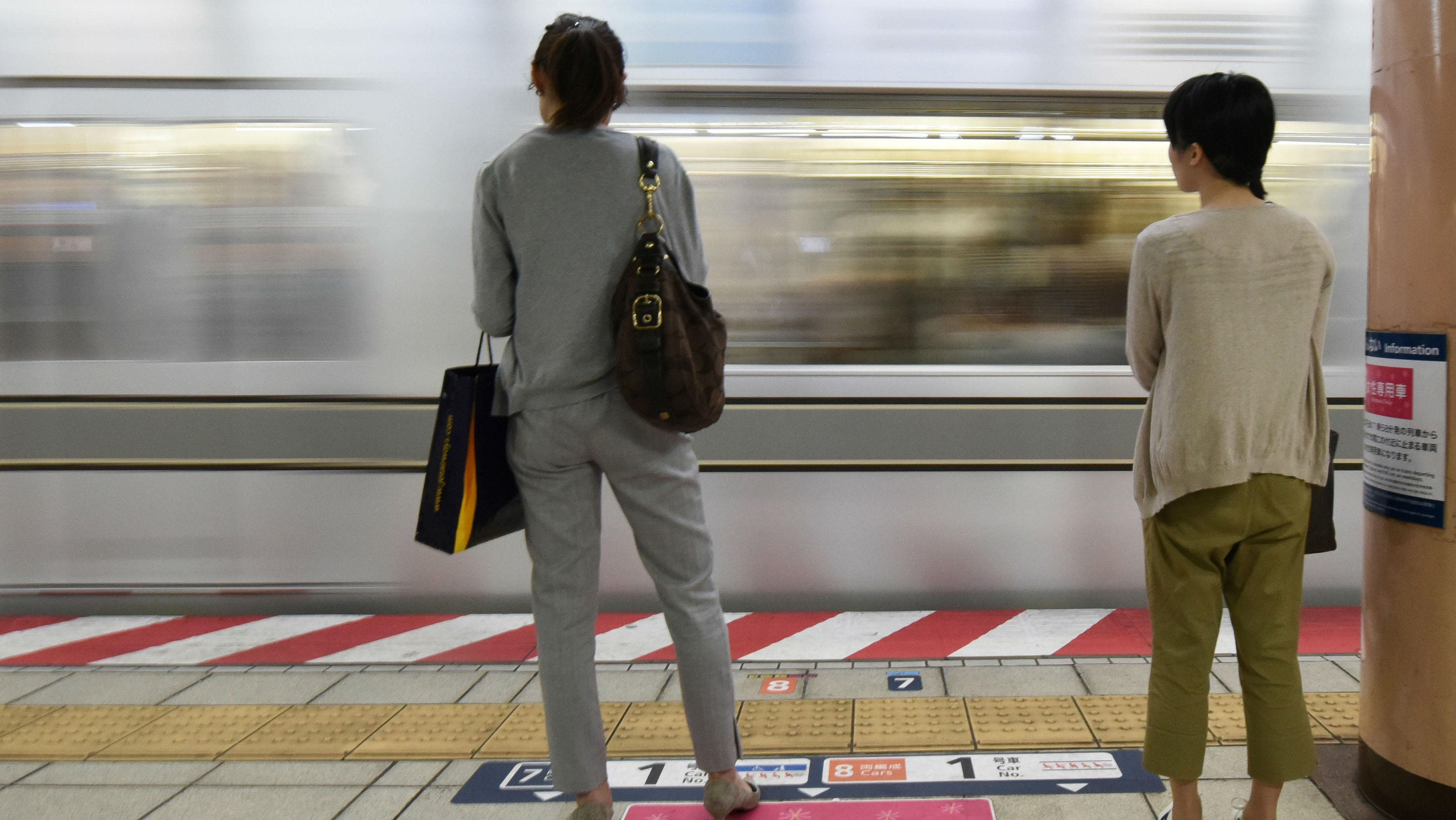 Women wait for a train in Japan