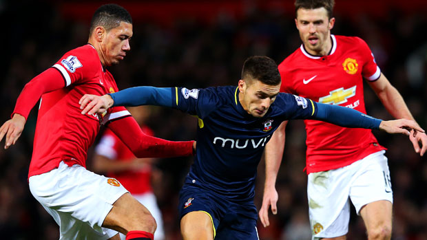 Dusan Tadic of Southampton battles for the ball with Chris Smalling and Michael Carrick of Manchester United 