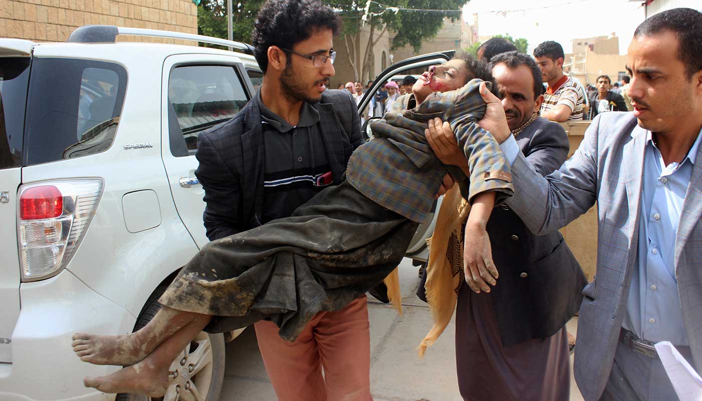 A child is transported to hospital following an airstrike that hit a school bus in Yemen