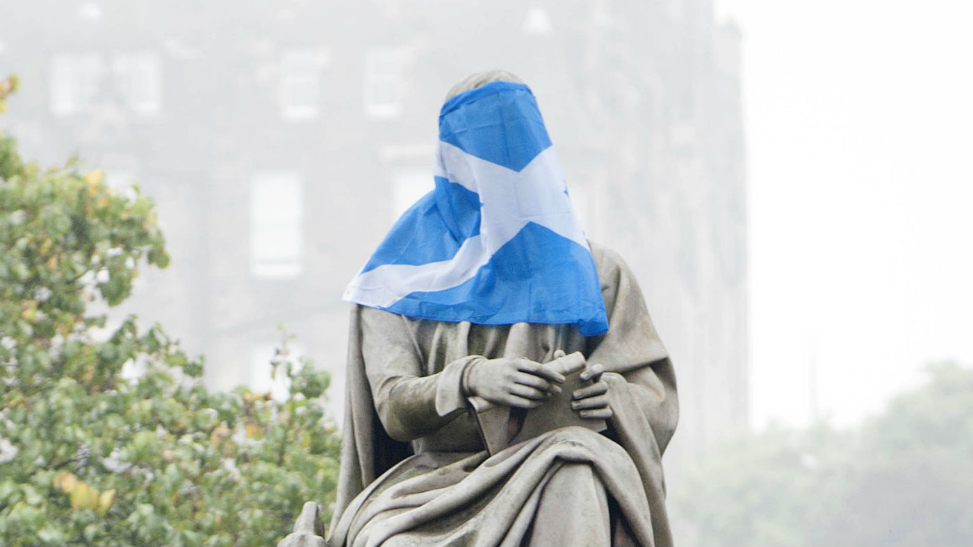 Scotland’s Saltire flag draped over a statue of Scottish novelist and playwright Sir Walter Scott in Edinburgh