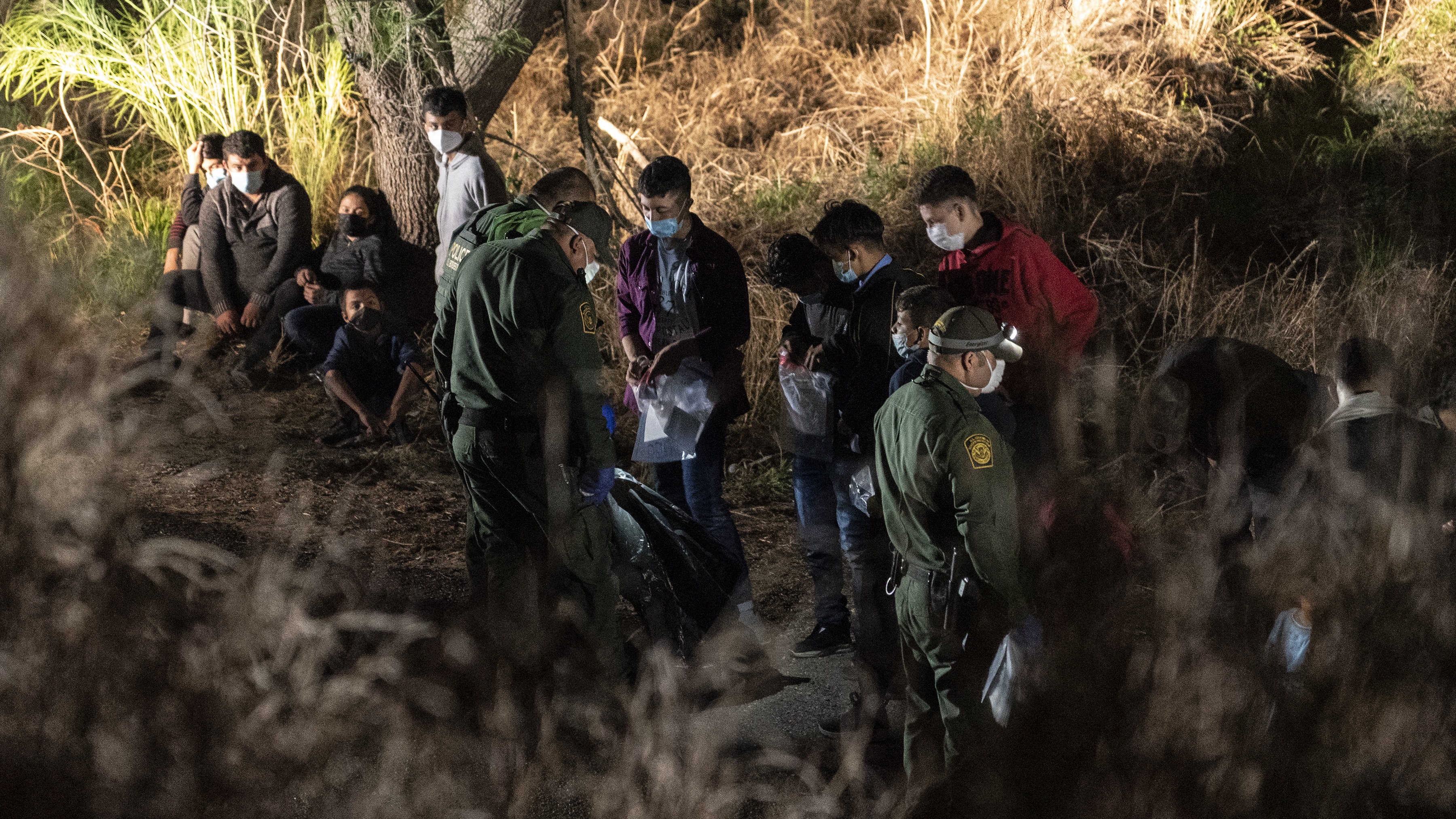 US border guards with a group of detained migrants 