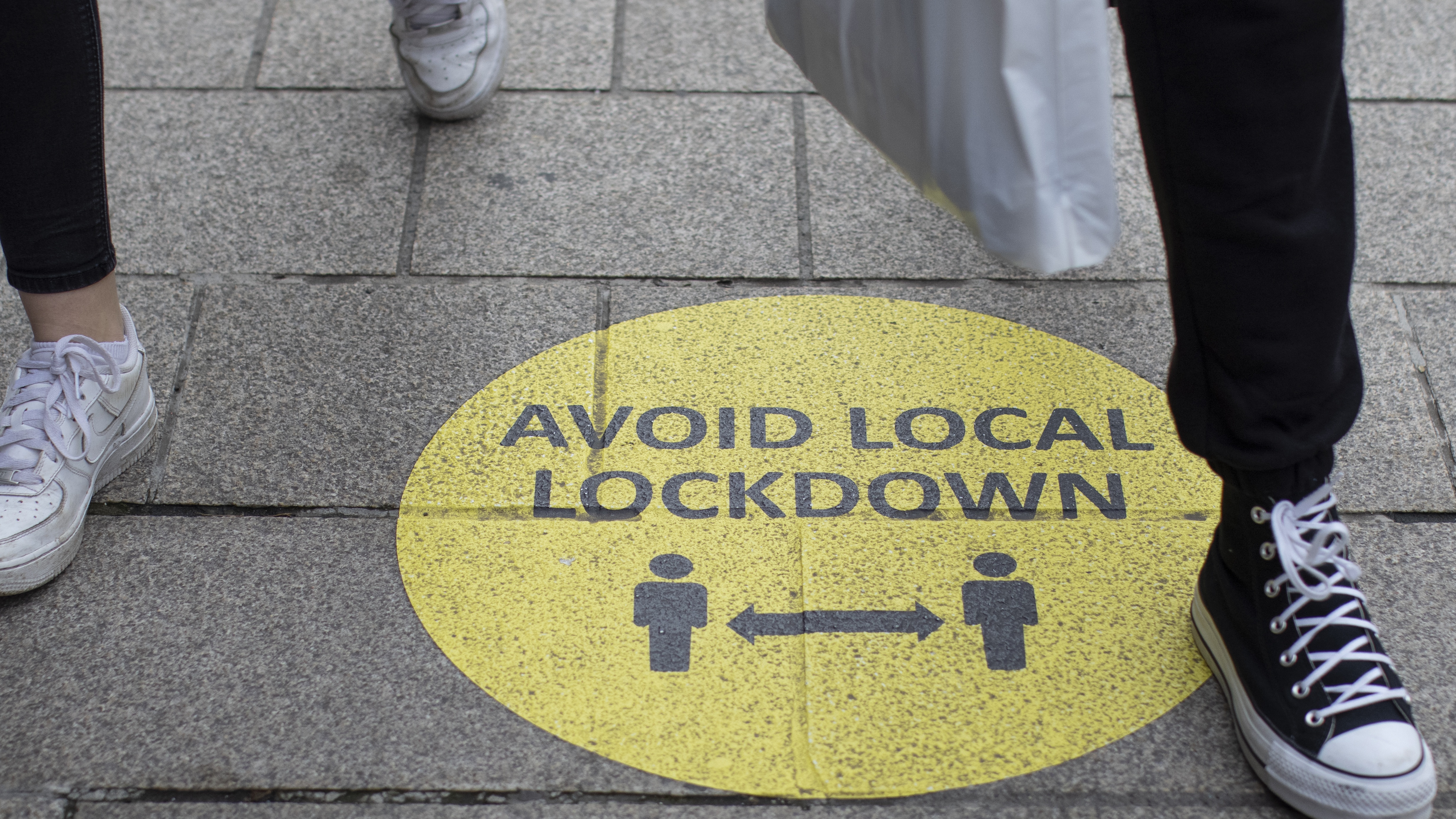 A sign warning people to socially distance to avoid local lockdowns