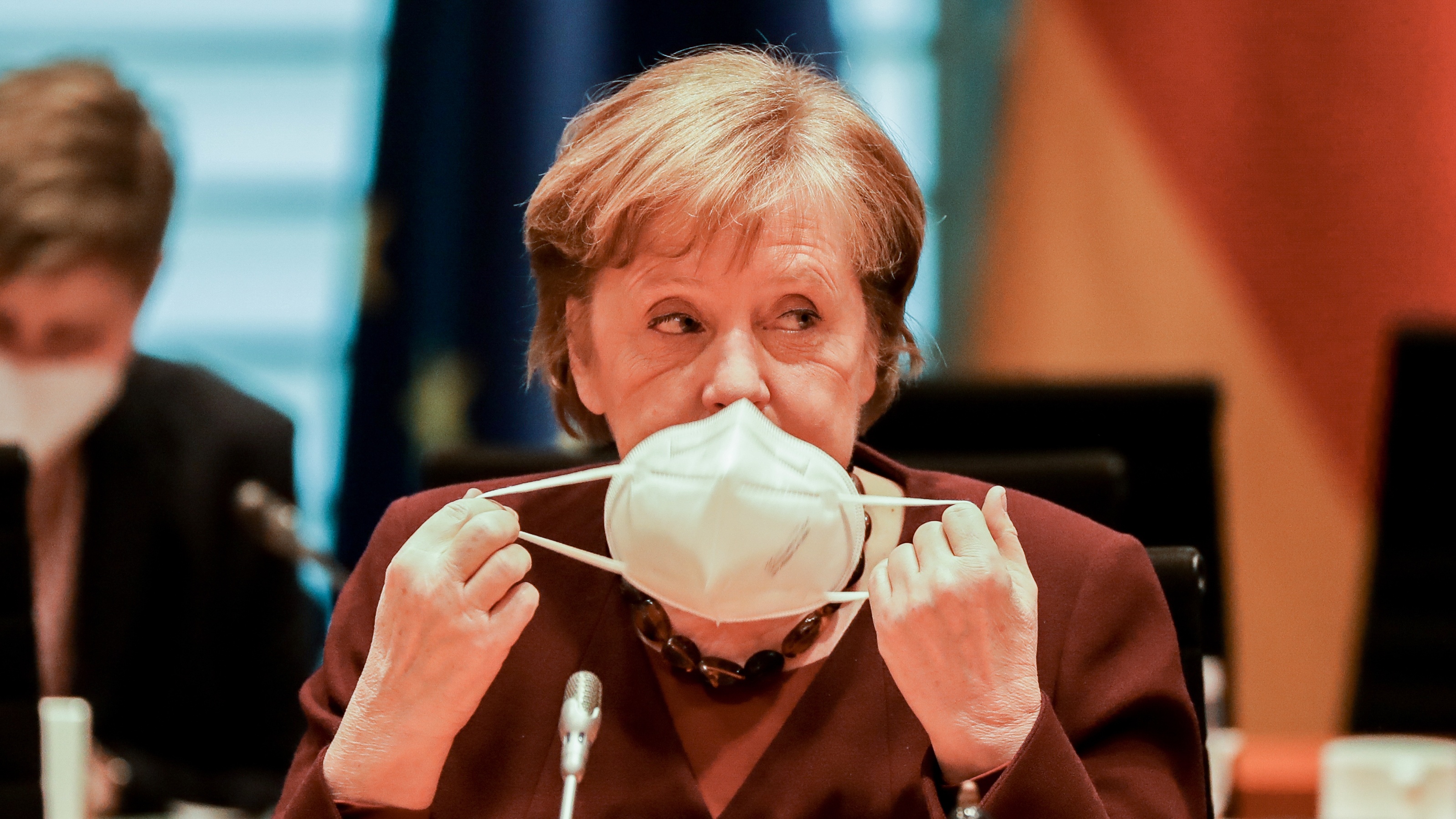 German Chancellor Angela Merkel puts on face mask
