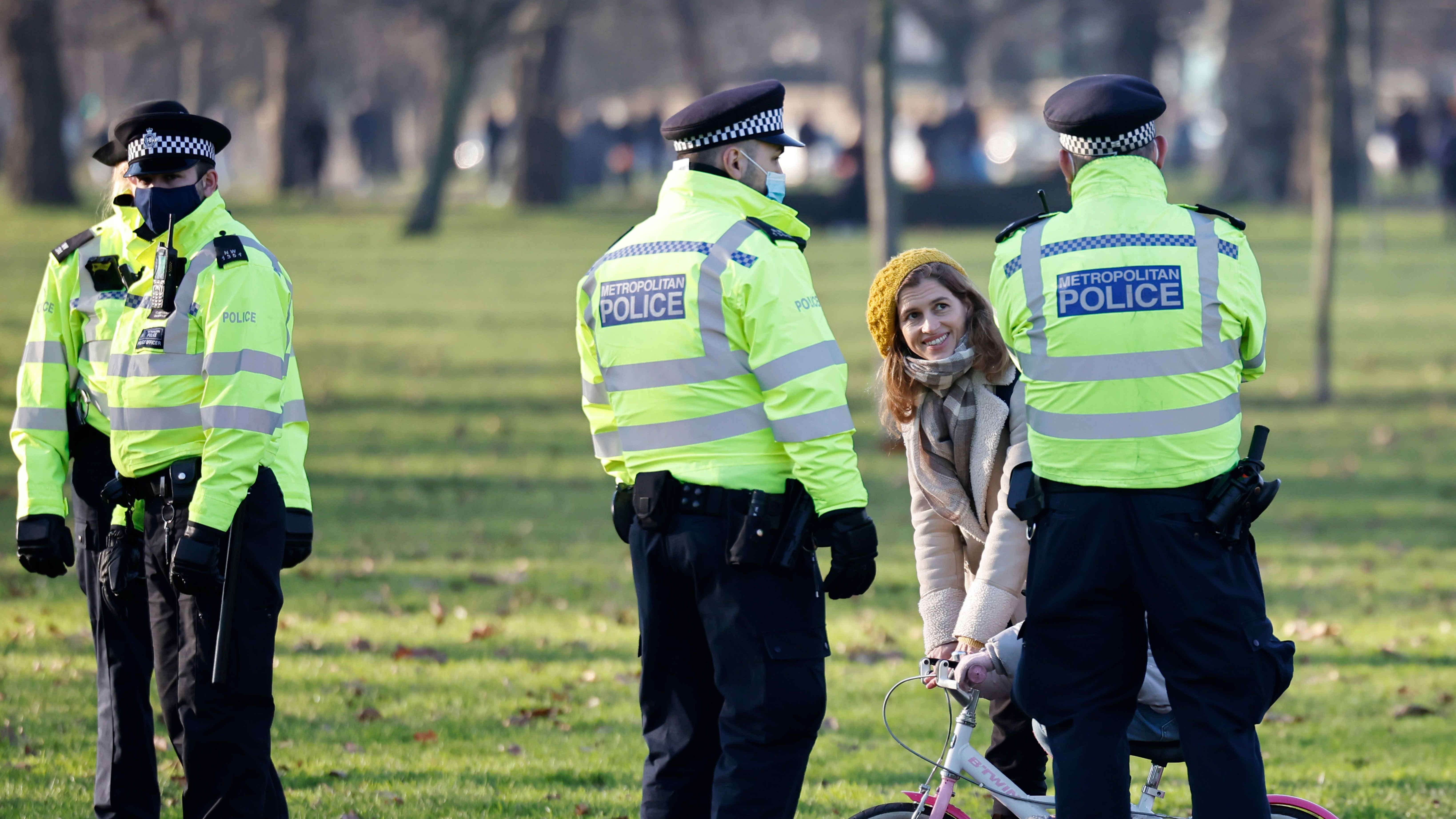 Police officers talk with a family as they patrol in Clapham Common, south London.