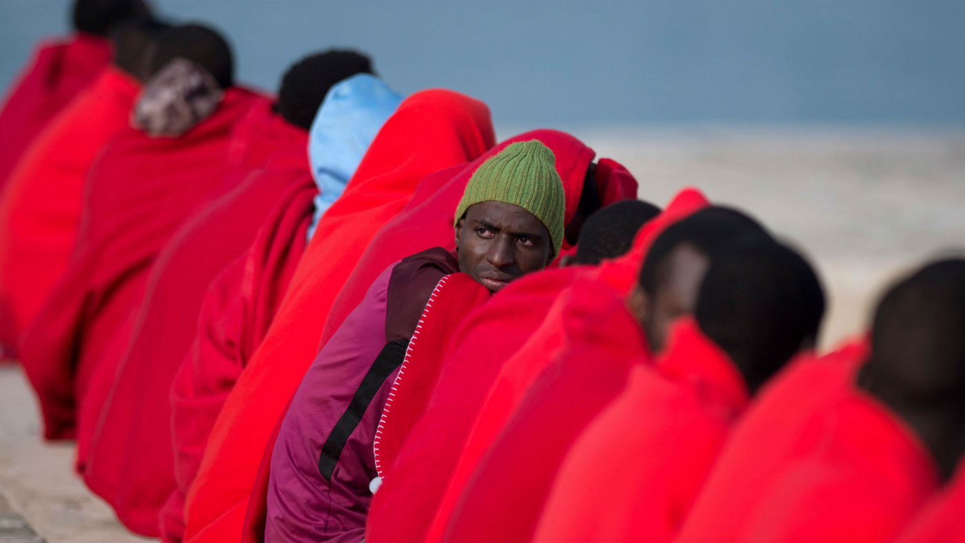Migrants keep warm with Red Cross blankets upon their arrival at Malaga harbour this year