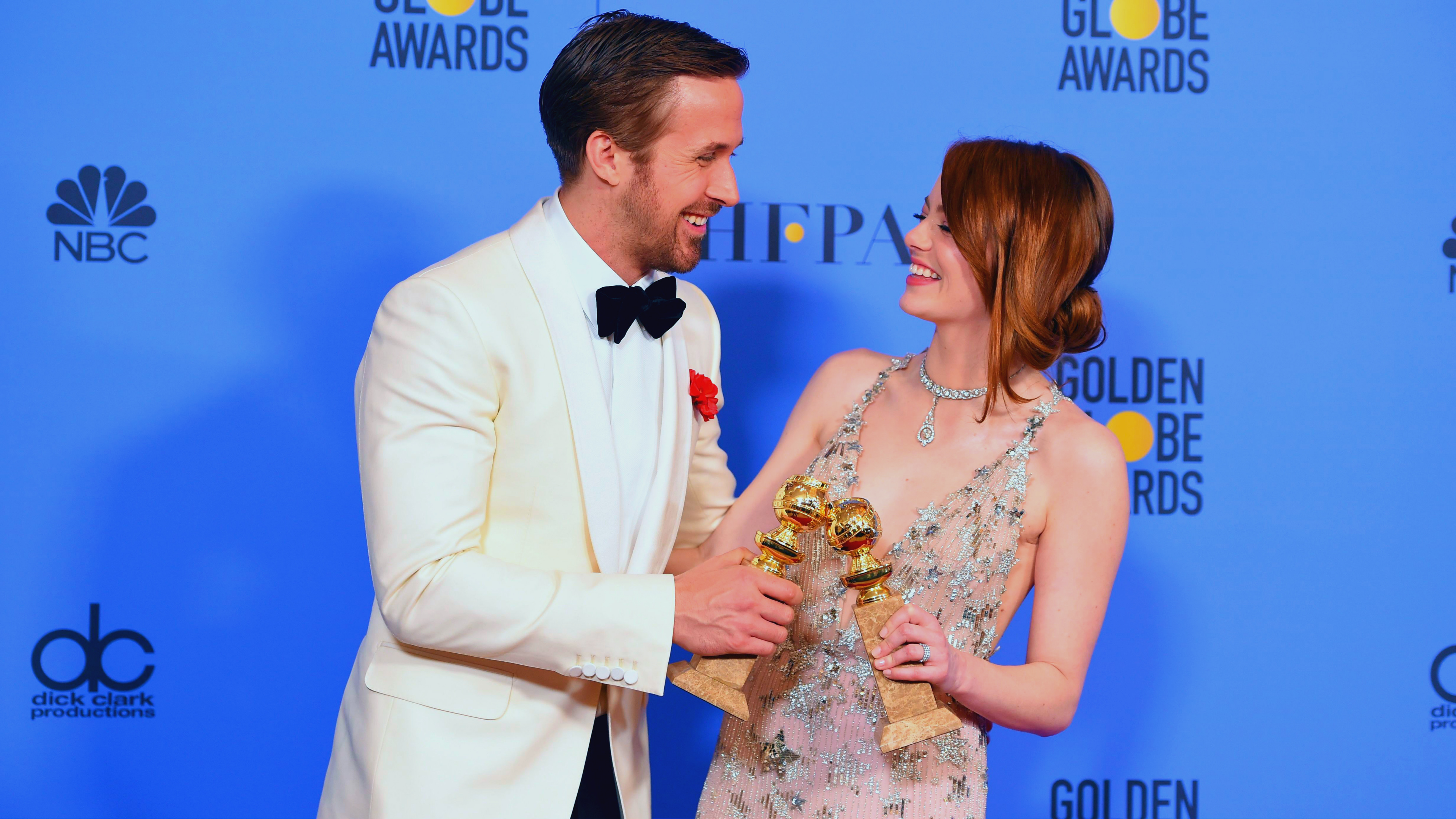 La La Land actors Ryan Gosling and Emma Stone pose with their Golden Globes after the ceremony in Beverly Hills