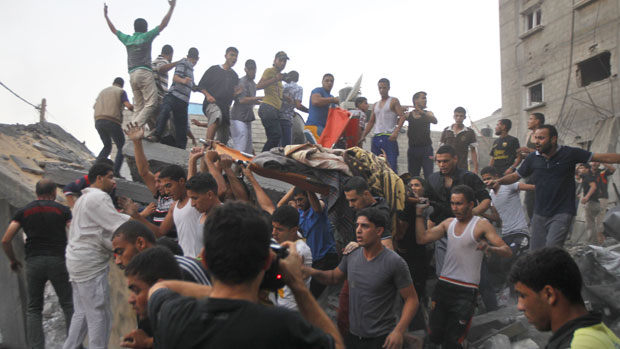 Palestinians carry the body of a woman killed in an Israeli air strike