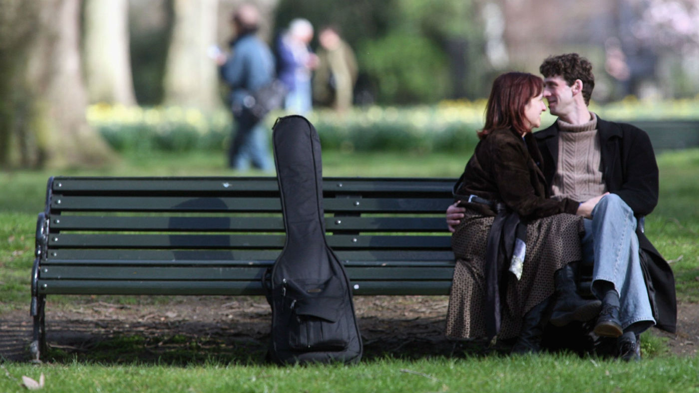 A couple sit on a bench in St James&#039;s Park in London
