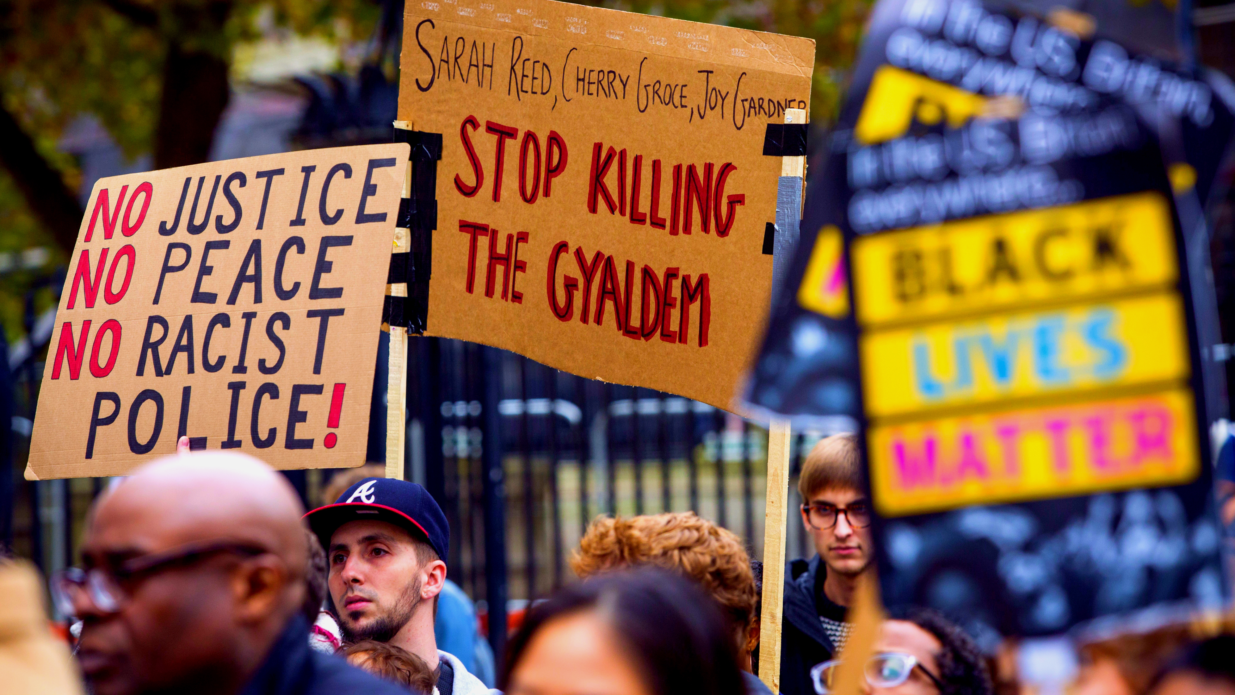 Protesters hold placards outside Downing Street during a demonstration to remember those who have died in police custody