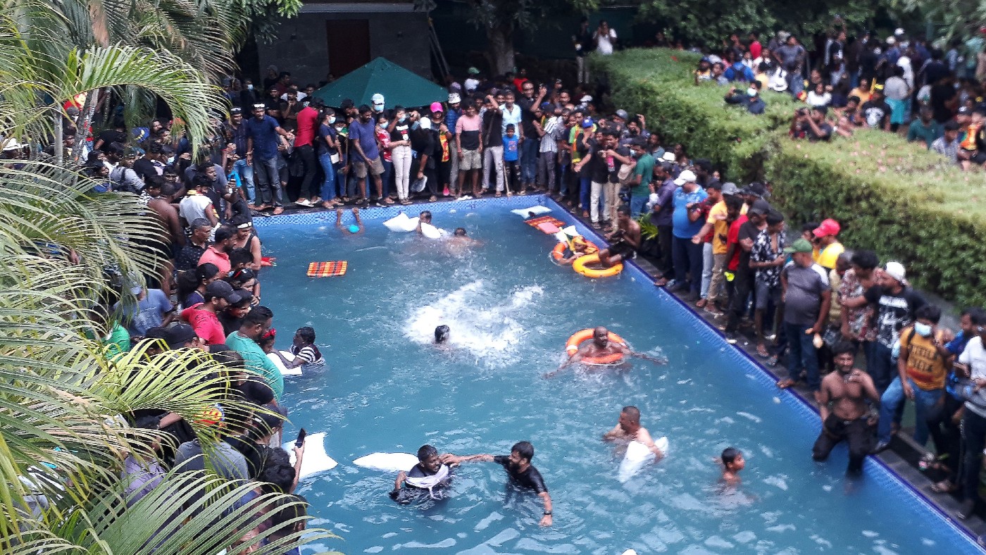 Protesters swim in a pool inside the president’s official residence