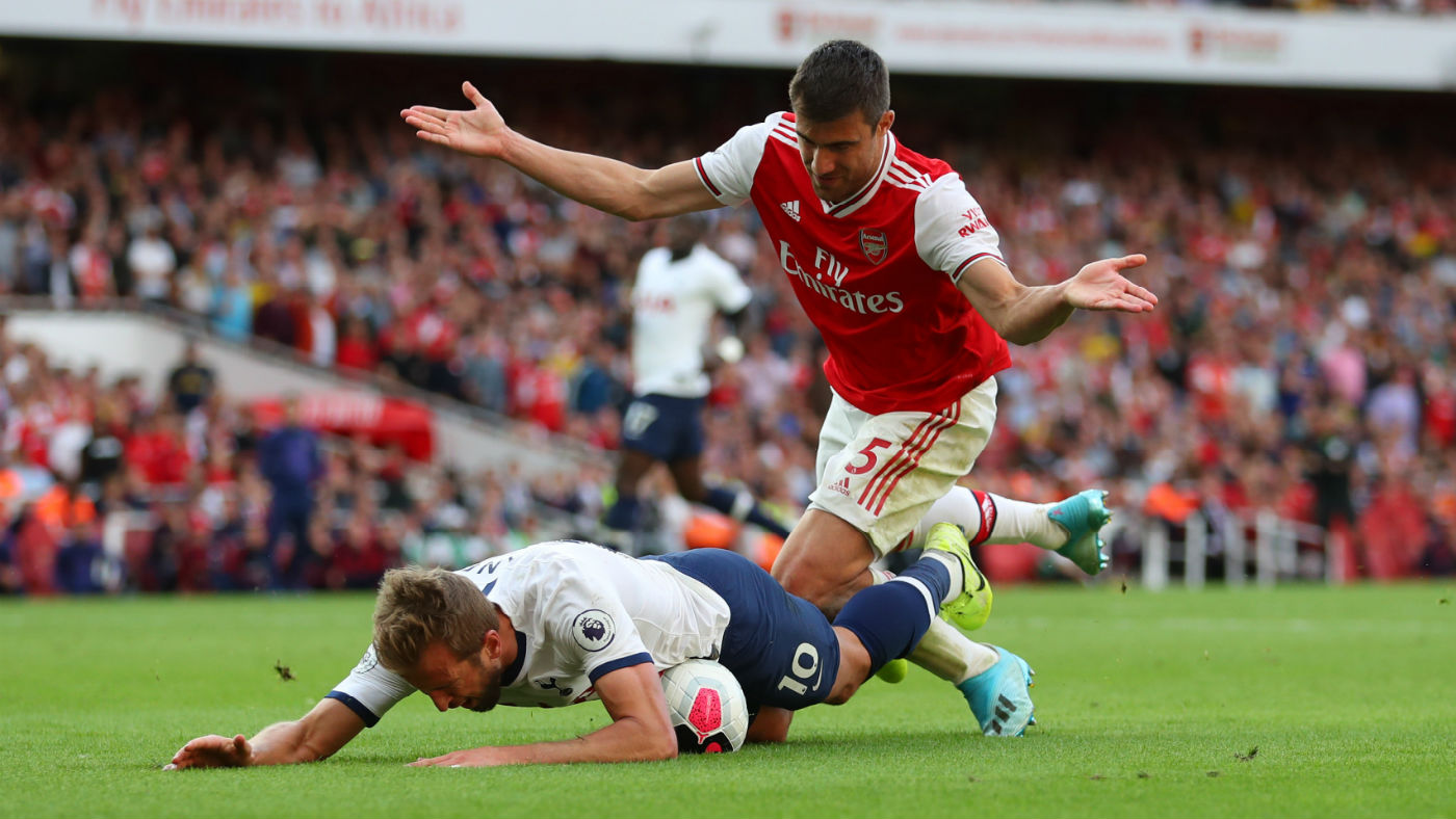 Tottenham striker Harry Kane goes down under a challenge from Arsenal defender Sokratis 