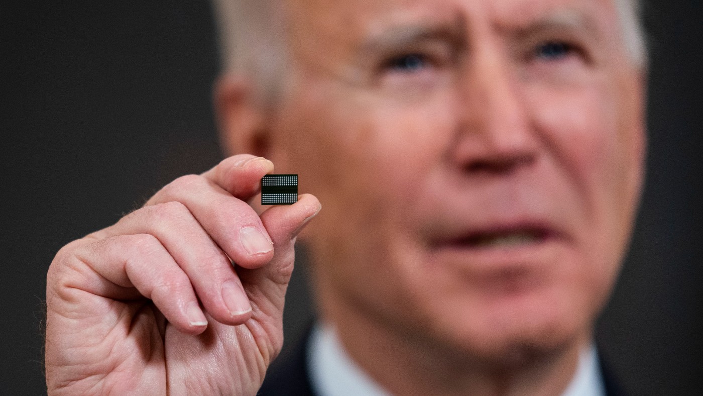US President Joe Biden holds a semiconductor chip   