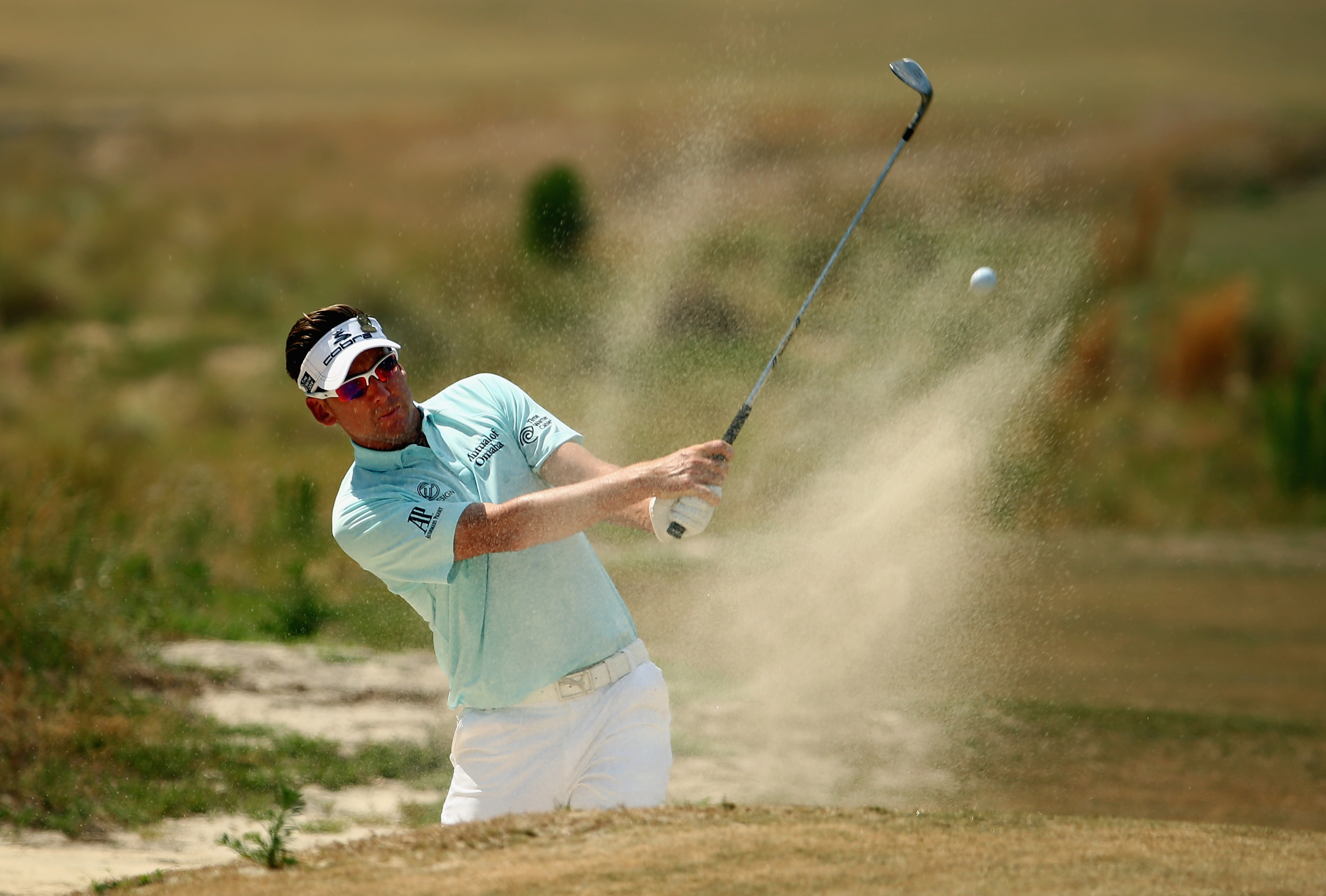 England&#039;s Ian Poulter hits a shot from a bunker 