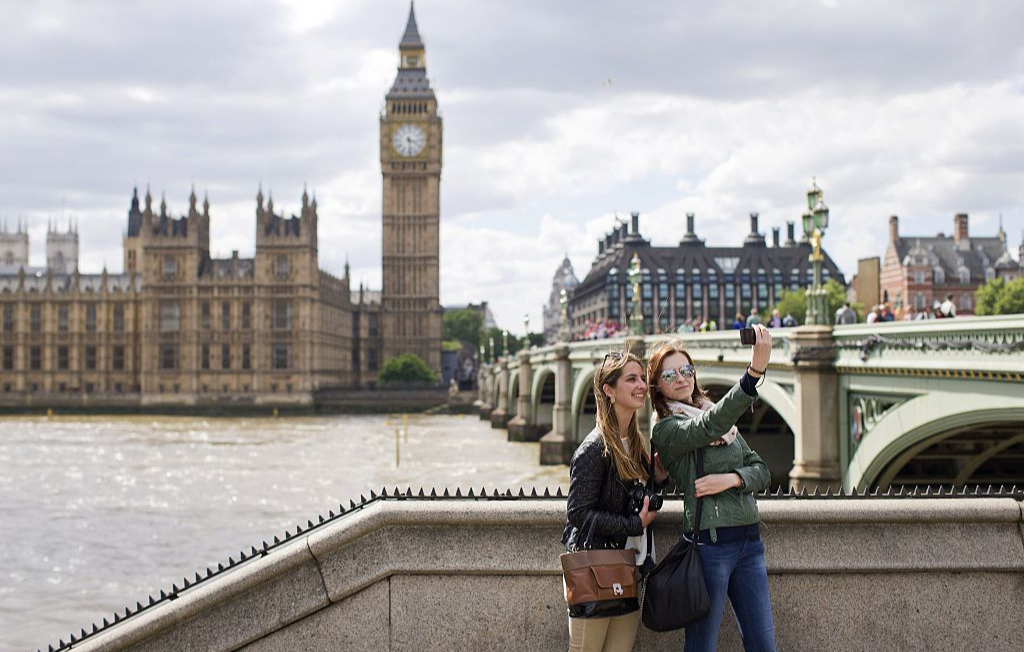 People take a selfie in front of the Houses of Parliament