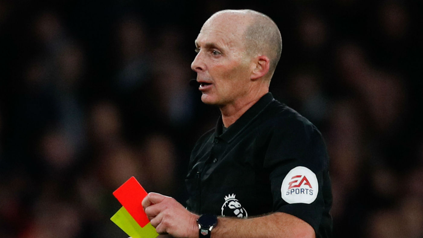 Referee Mike Dean shows a red card during a Premier League fixture
