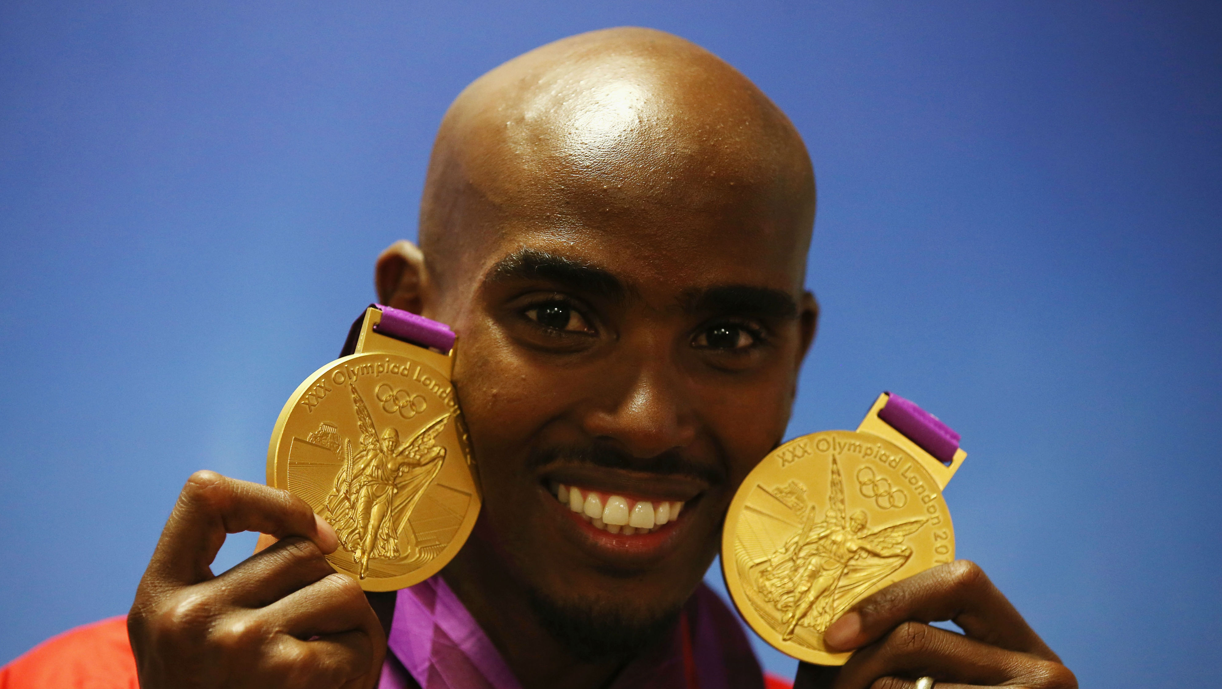 Gold medalist Mohamed Farah of Great Britain poses with his medals for the 10,000m and 5000m