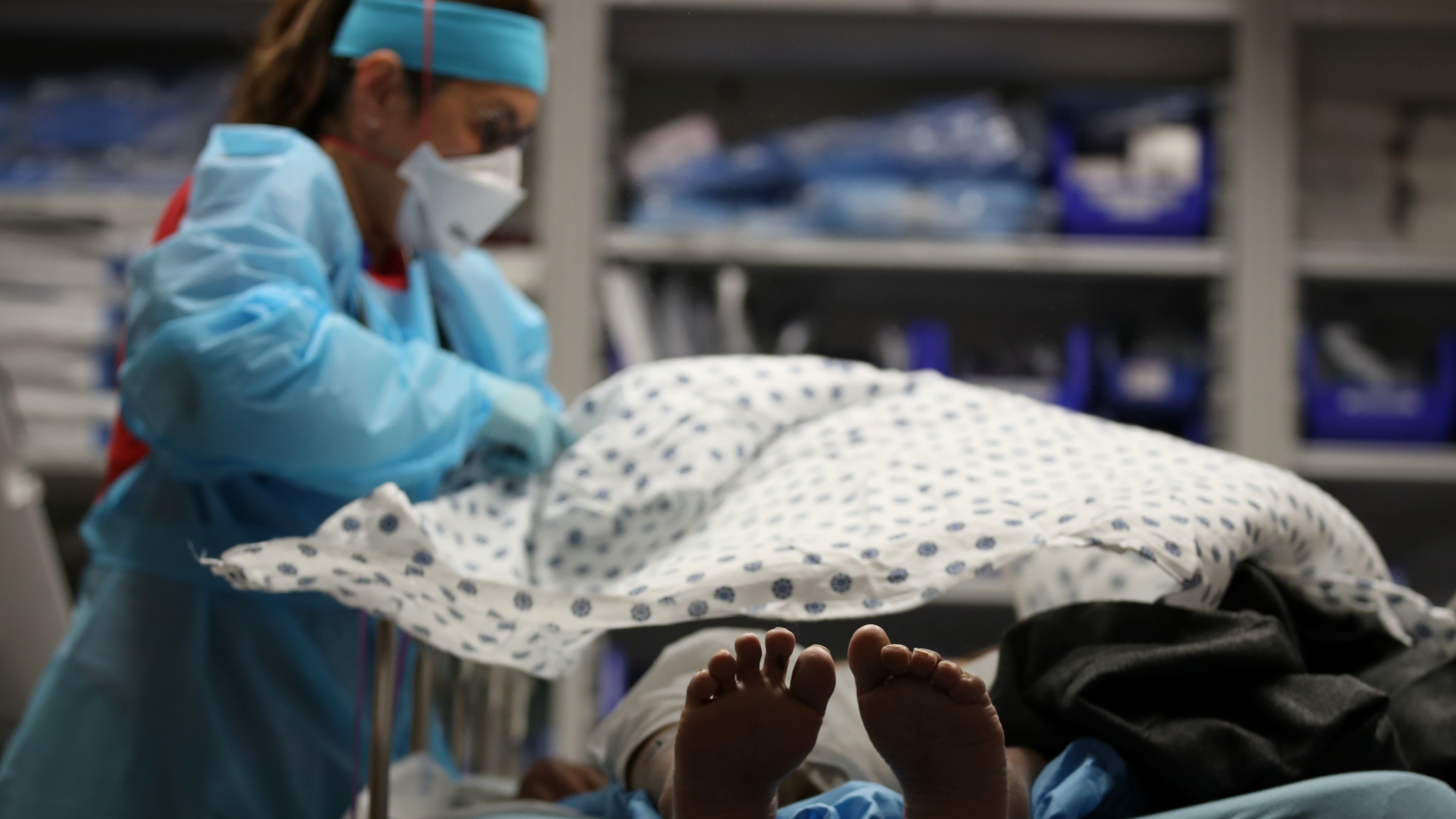 A nurse places a blanket over a Covid patient in San Jose, California
