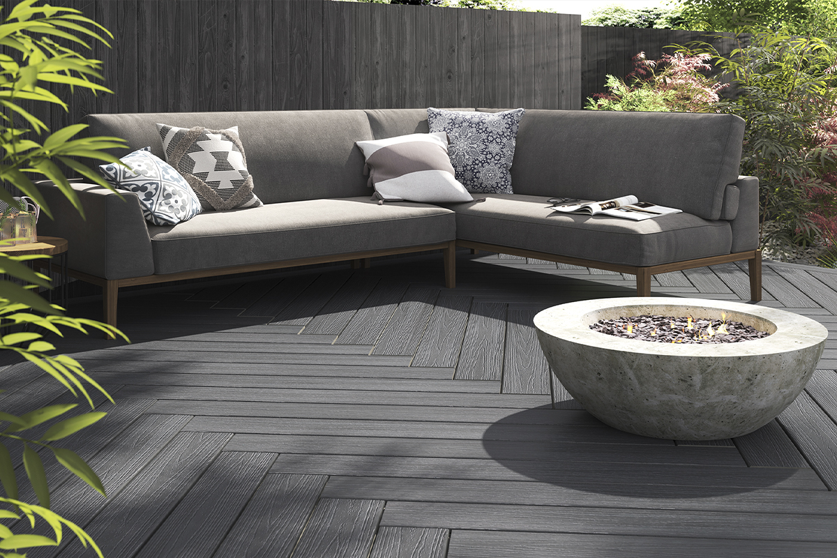 Outdoor decking with a semi-spherical fire pit set in front of an L-shaped sofa