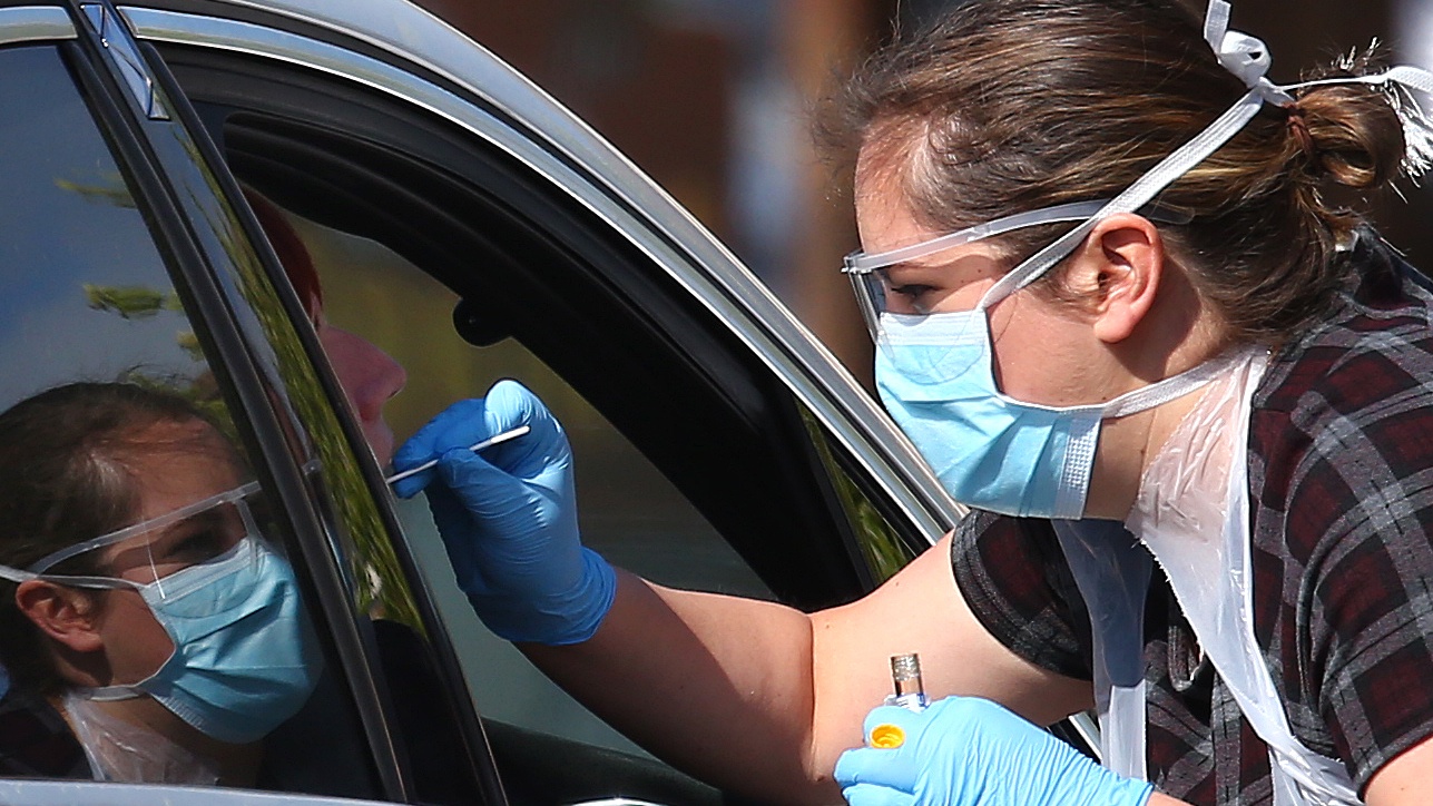 A medical worker takes a swab at a drive-in Covid-19 testing centre in Chessington.