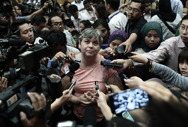 A relative (C) of a passenger of the missing Malaysia Airlines flight MH370 talk to journalists after the Department of Civil Aviation (DCA) decided to cancel a press conference in Putrajaya 