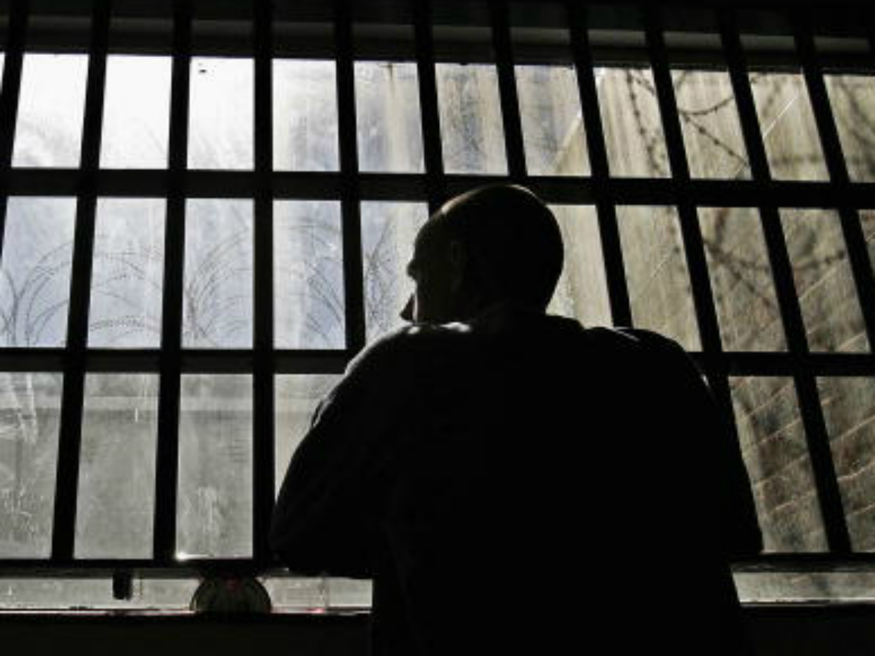 A prisoner stares through bars