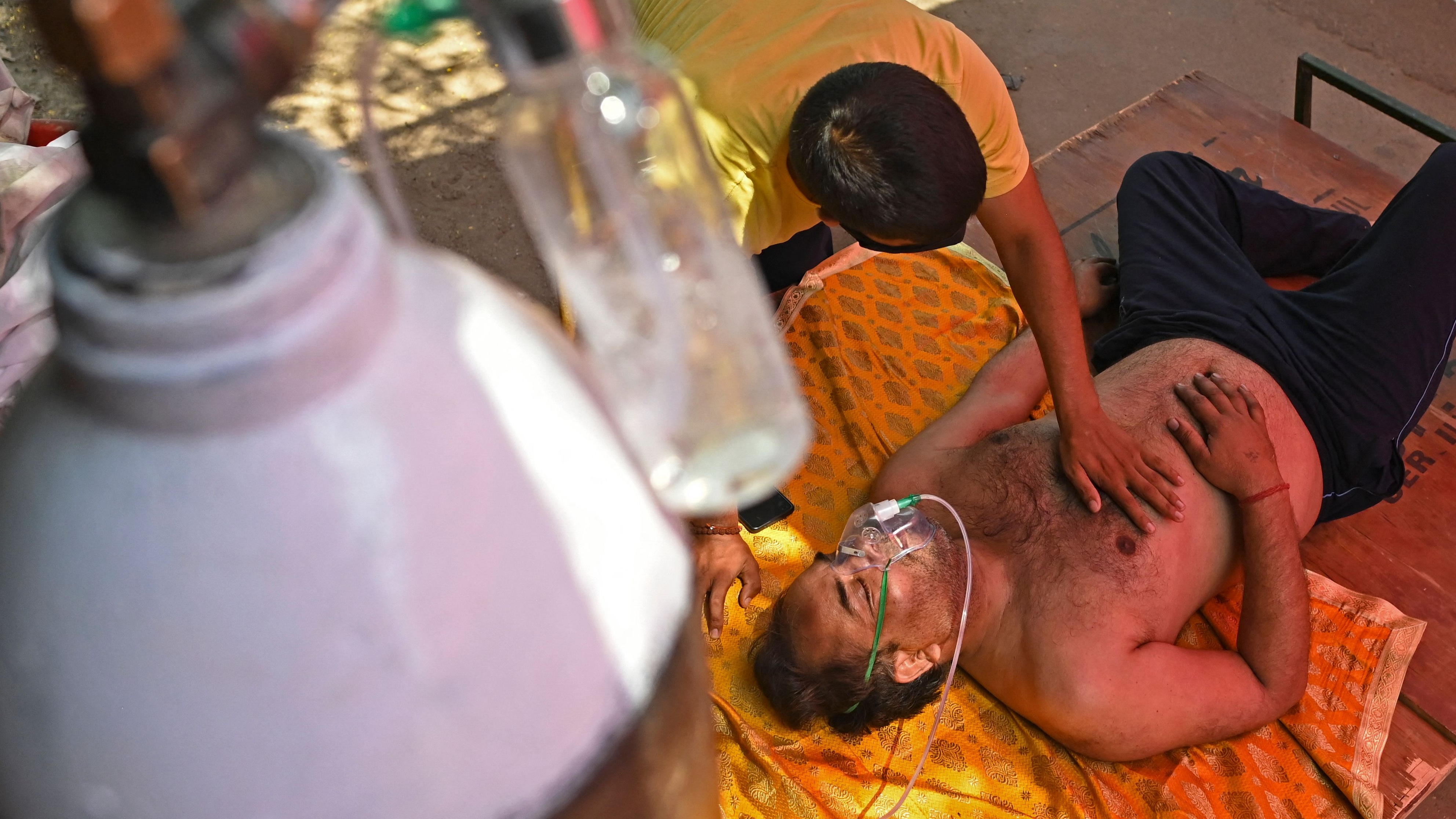 A Covid patient breathes with the help of oxygen in a tent outside a Sikh Gurdwara
