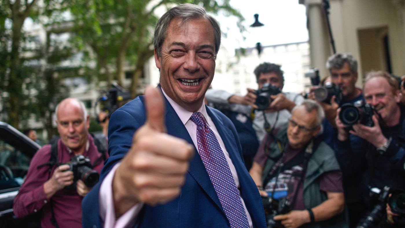 Nigel Farage gives a thumbs up to waiting photographers.