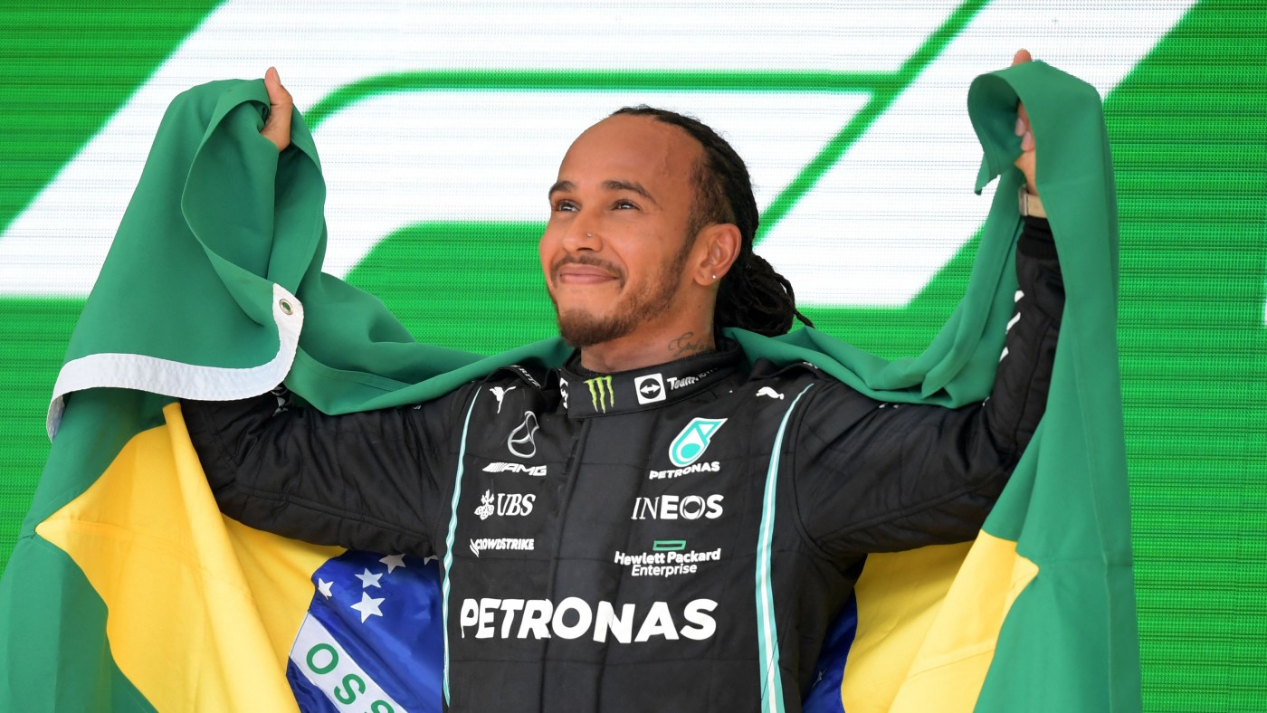 Mercedes’ British driver Lewis Hamilton celebrates on the podium at Interlagos 