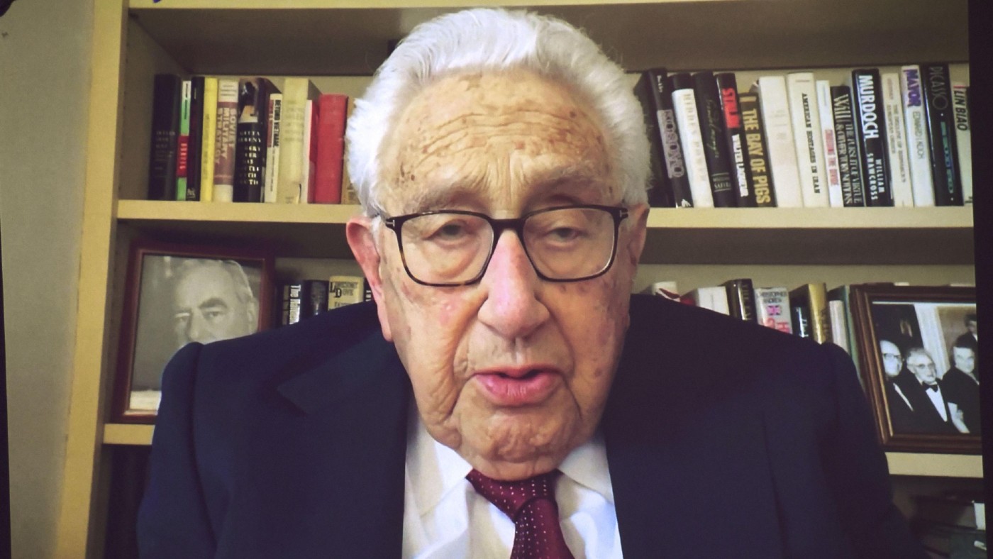 Henry Kissinger on a screen