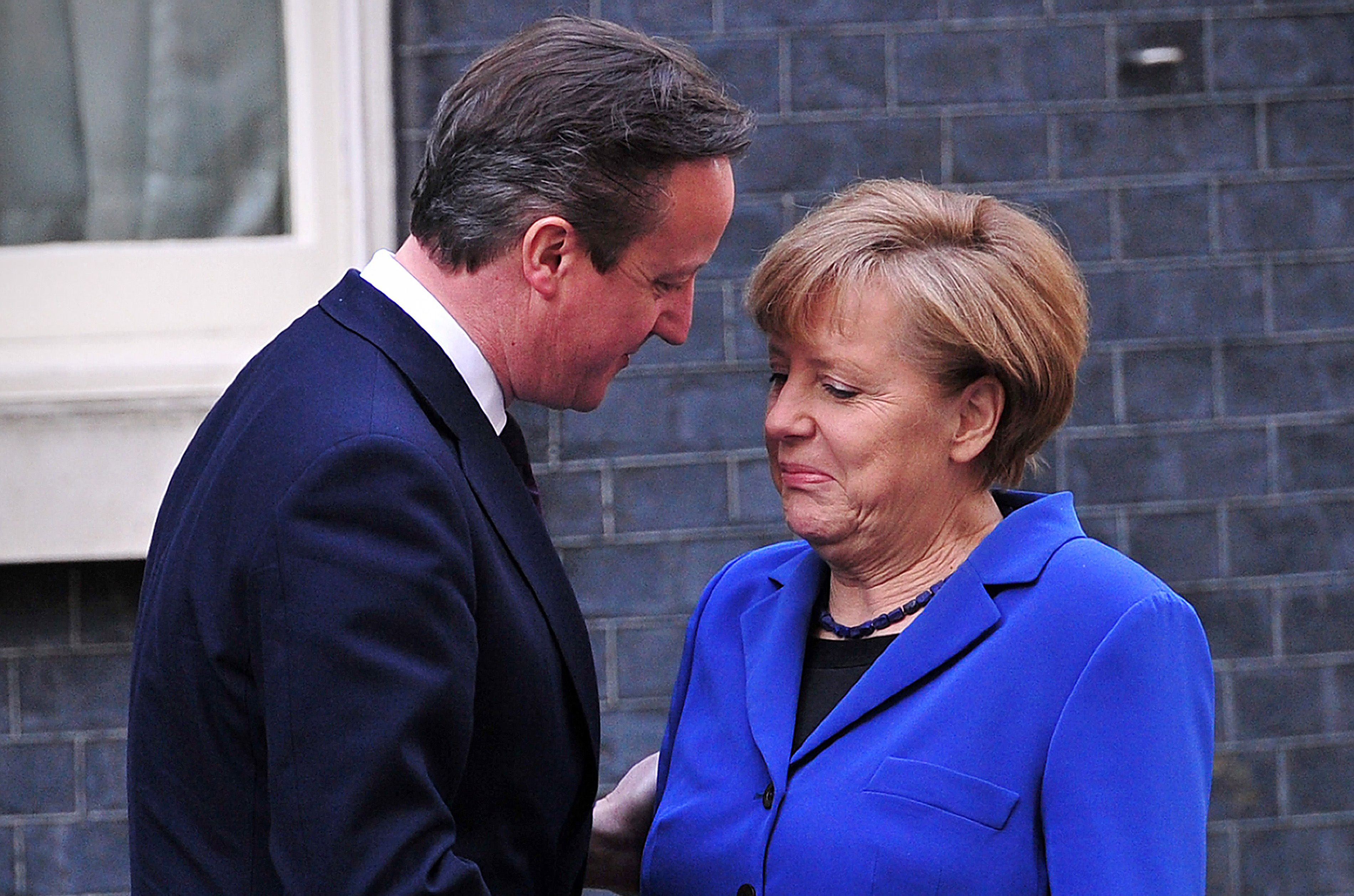 British Prime Minister David Cameron (L) greets German Chancellor Angela Merkel outside 10 Downing Street in London, on February 27, 2014. Merkel on Thursday urged Britain to stay in the Euro