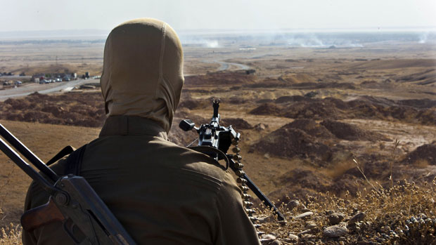 A Kurdish Peshmerga fighter takes position over Islamic State militants