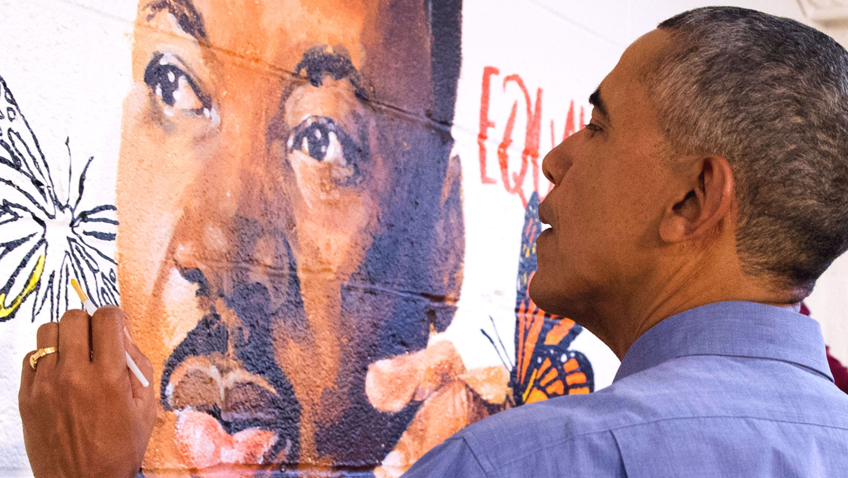 Barack Obama helps paint a mural depicting Martin Luther King Jr at a family shelter in Washington DC