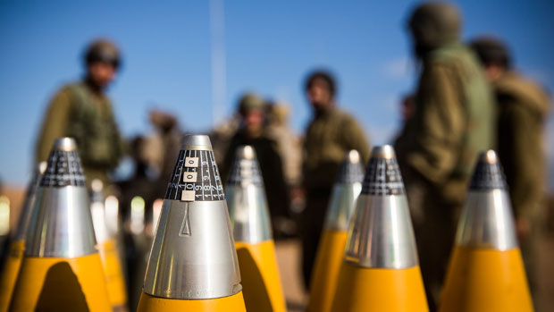 Israeli troops with artillery shells waiting to be fired into Gaza