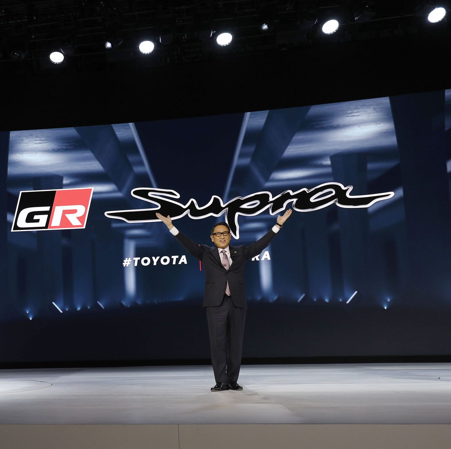 DETROIT, MI -JANUARY 14: Akio Toyoda, President of Toyota Motor Corporation, stands with The 2020 Toyota Supra rear-wheel-drive sports coupe at its reveal at the 2019 North American Internati