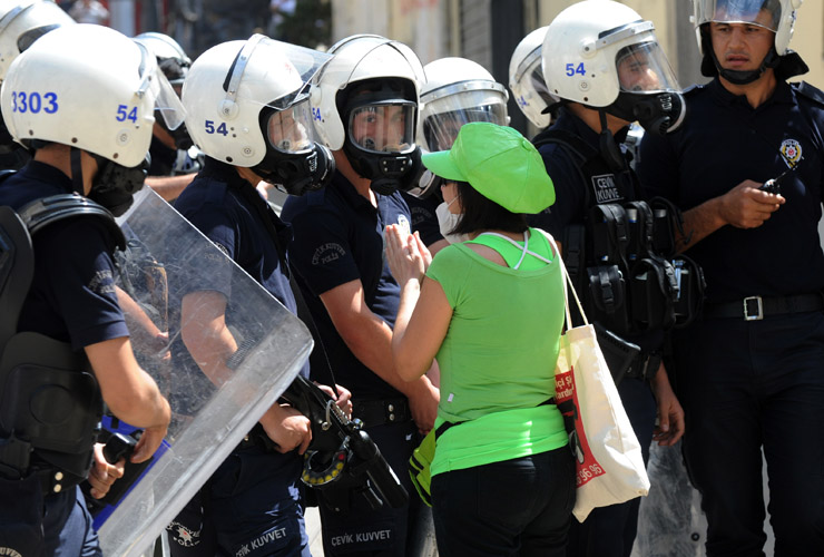 A women asks police to stop as Turkish protestors and riot policemen clash on June 1, 2013, during a protest against the demolition of Taksim Gezi Park, in Taksim Square in Istanbul. Police r