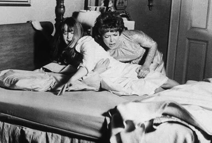 1973, American actor Ellen Burstyn restrains American actor Linda Blair on a bed in a still from the film &#039;The Exorcist&#039;, directed by William Friedkin. (Photo by Warner Bros./Getty Images)