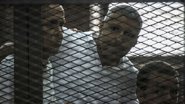 Journalists Peter Greste, Mohamed Fadel Fahmy, and Egyptian Baher Mohamed listen to the court&#039;s verdict